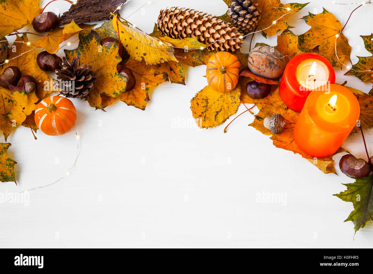 Herbstliche Rahmen-Dekoration mit Eicheln, Kastanien, Tannenzapfen, Blätter, Kürbisse, Kerzen Stockfoto