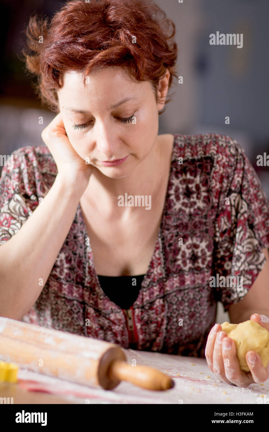 Traurig und einsam wirkende Frau in tiefe Gedanken während des Kochens Stockfoto