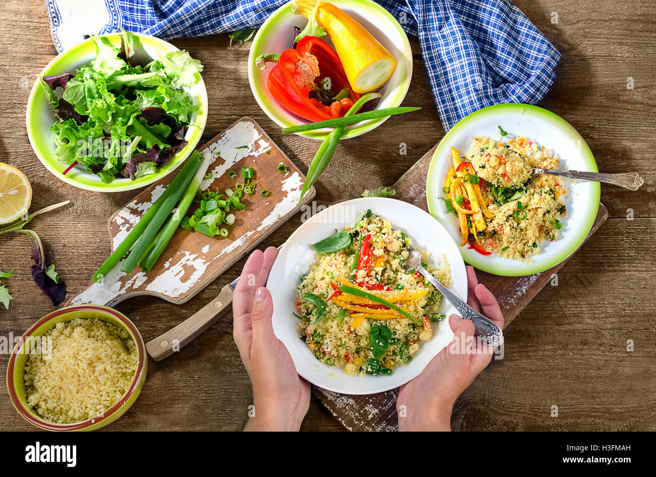 Frau Hände Halteplatte Couscous mit Gemüse.  Ansicht von oben Stockfoto