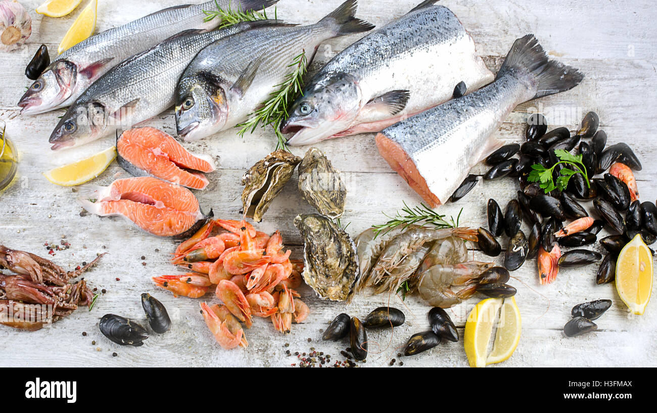 Roher Fisch und andere Meeresfrüchte auf hölzernen Hintergrund. Stockfoto