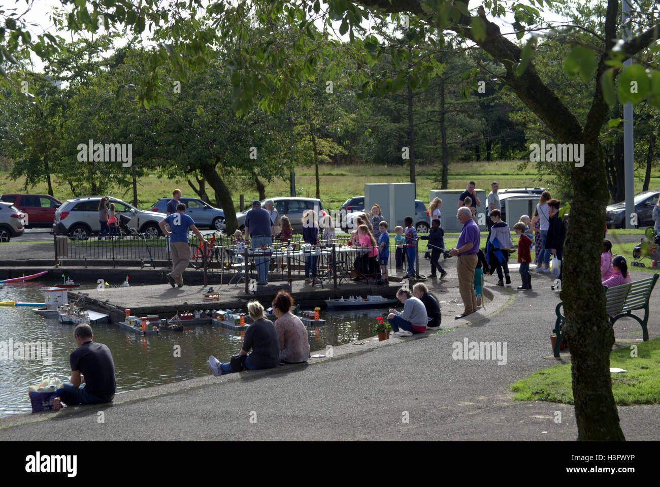 Modell Boot worunter Trawler Spielzeug Docks und Segelboot während der lokalen Feierlichkeiten am Tag der offenen Tür im Knightswood Park. Stockfoto