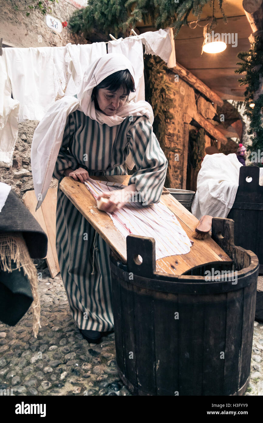 Riva del Garda, Italien - 26. Dezember 2015: Wäscherin wäscht Kleidung mit Wasser und Seife auf einem Holzbrett. Stockfoto