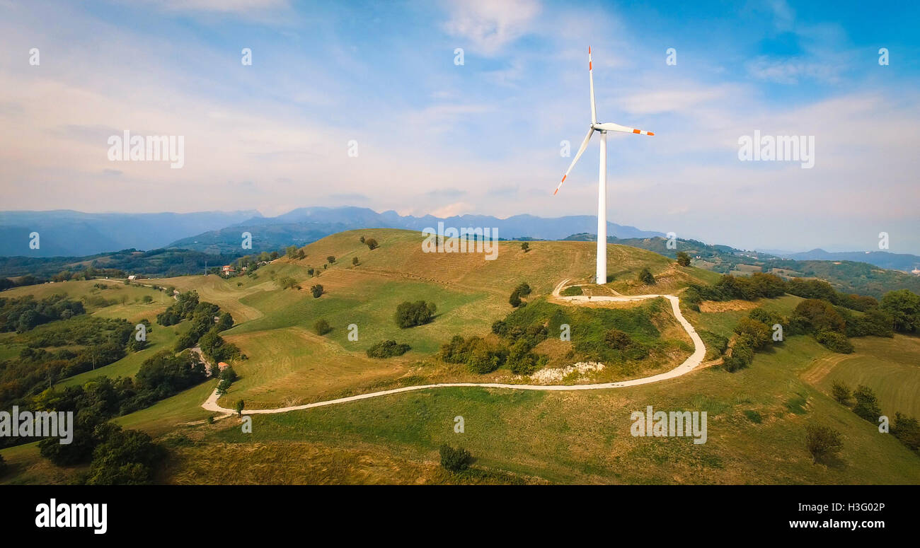 Einzelne Windturbine auf dem grünen Hügel. Stockfoto