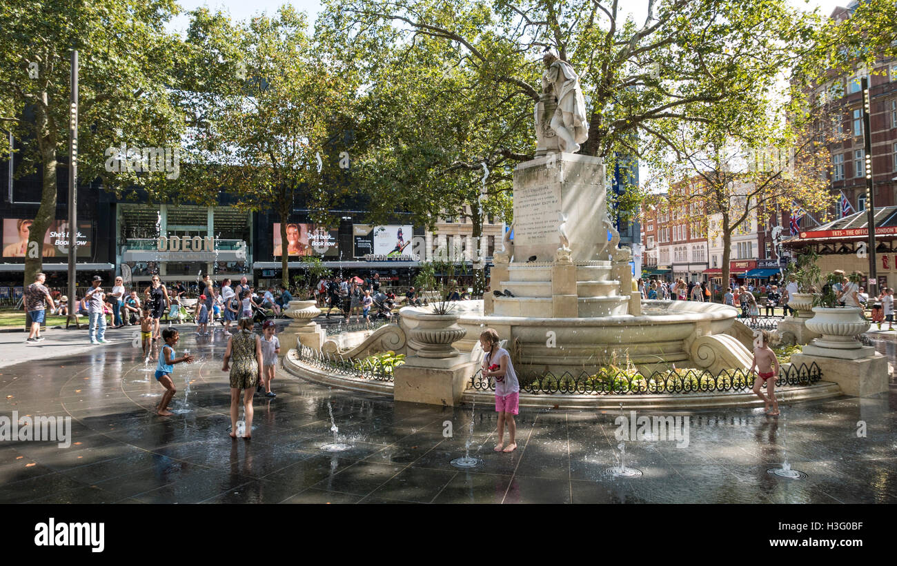 Kinder spielen in den Brunnen am Leicester Square im Zentrum von London Stockfoto