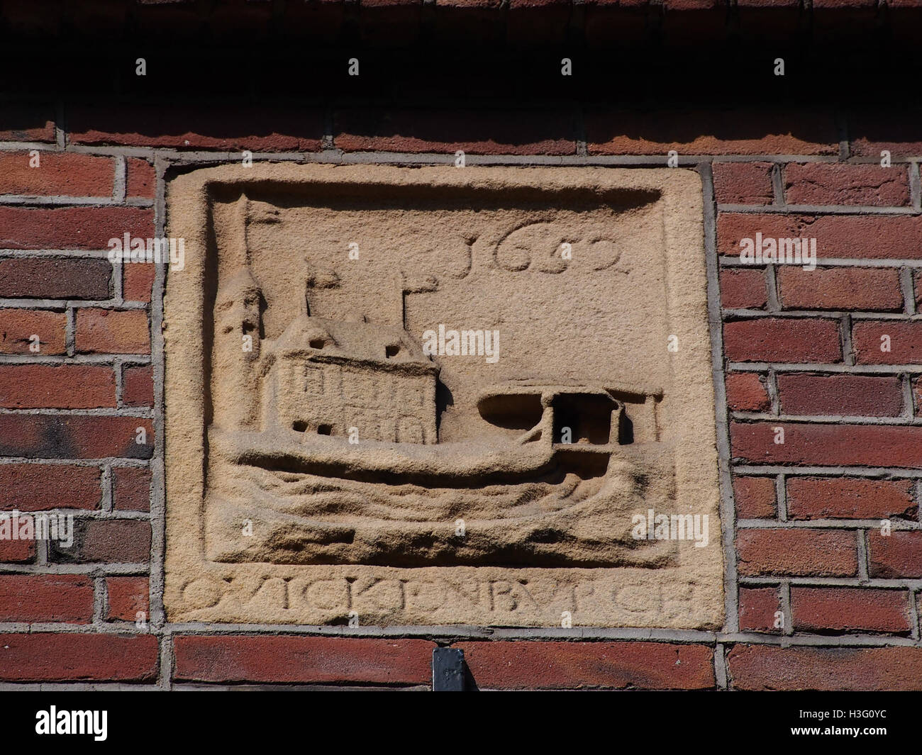 Dieses Bild zeigt das architektonische Detail des Gevelsteen (Fassadensteins) in der Grote Bickersstraat in Amsterdam. Die Inschrift auf dem Stein, „Qvickenbvrch“, unterstreicht die historische Bedeutung des Entwurfs des Gebäudes und seine Verbindung mit dem Erbe der Stadt. Stockfoto