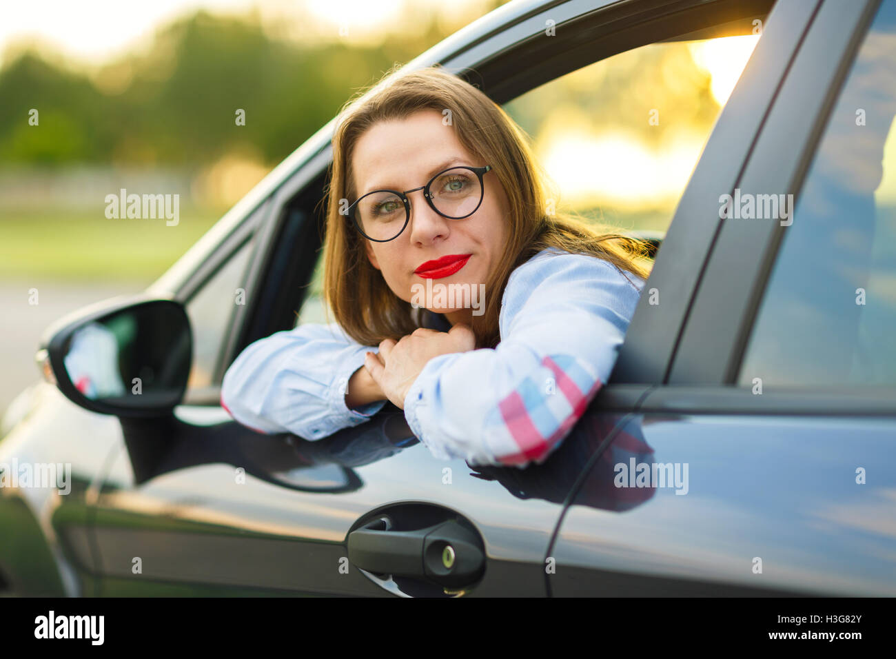 Glückliche Mädchen sitzen in einem Auto - Konzept für den Kauf eines Gebrauchtwagens oder einen Mietwagen Stockfoto