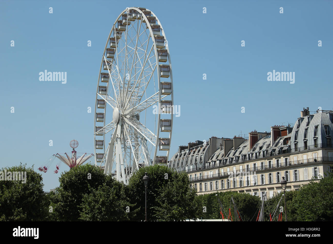 Riesenrad und Karussell auf dem blauen Himmel in Paris Stockfoto