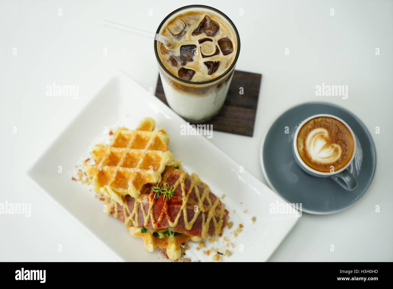 Belgische Waffeln mit Kaffee Latte und Iced Coffee auf weißem Hintergrund Stockfoto