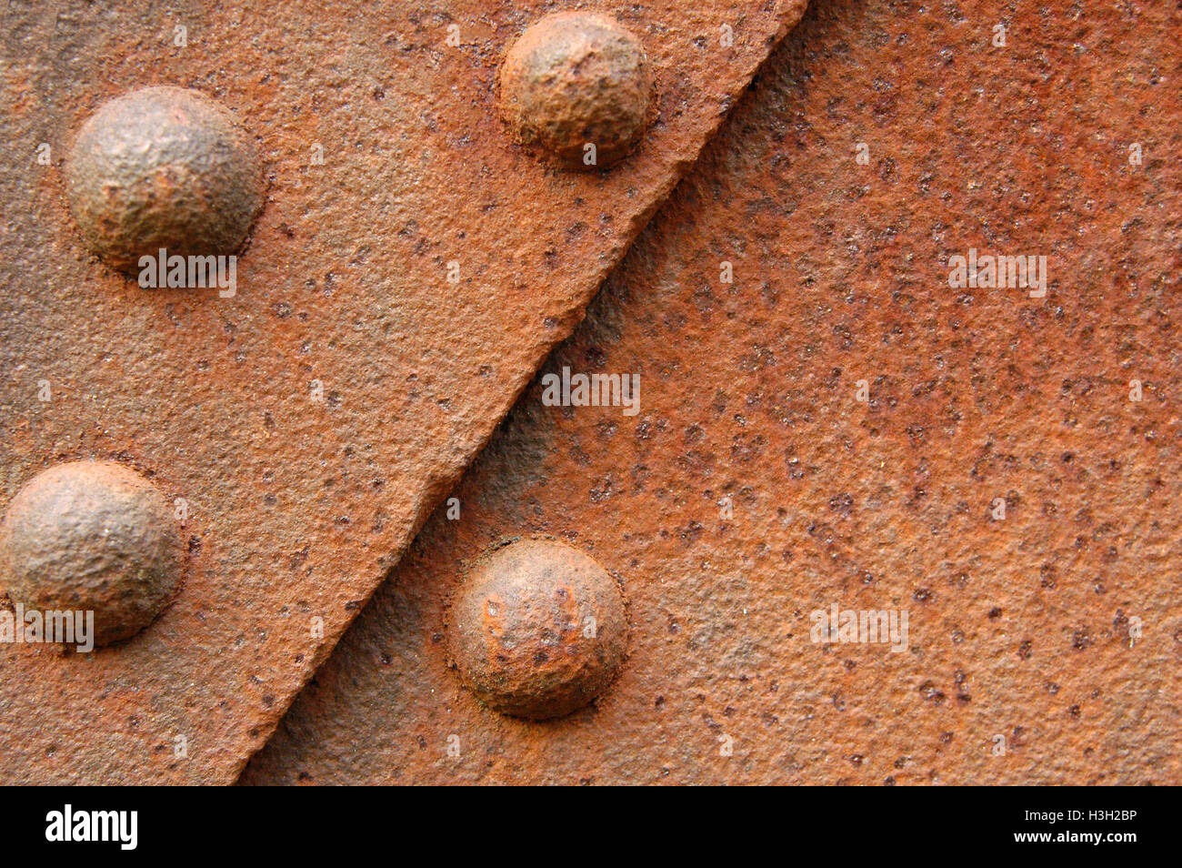 Rostige Stahlplatten mit Nieten zusammengehalten. Stockfoto