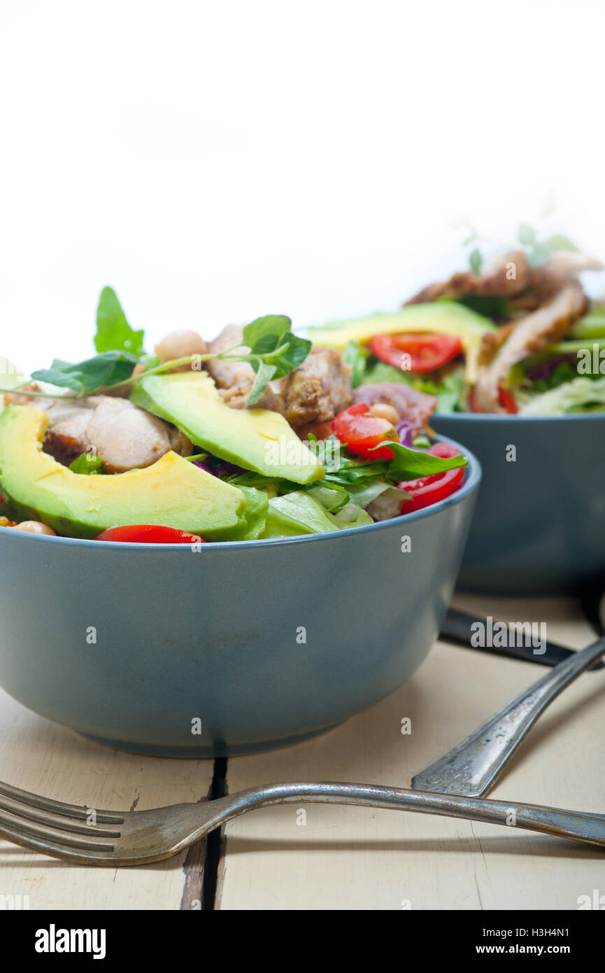 Frische und gesunde Hähnchen Avocado Salat über rustikalen Holztisch Stockfoto