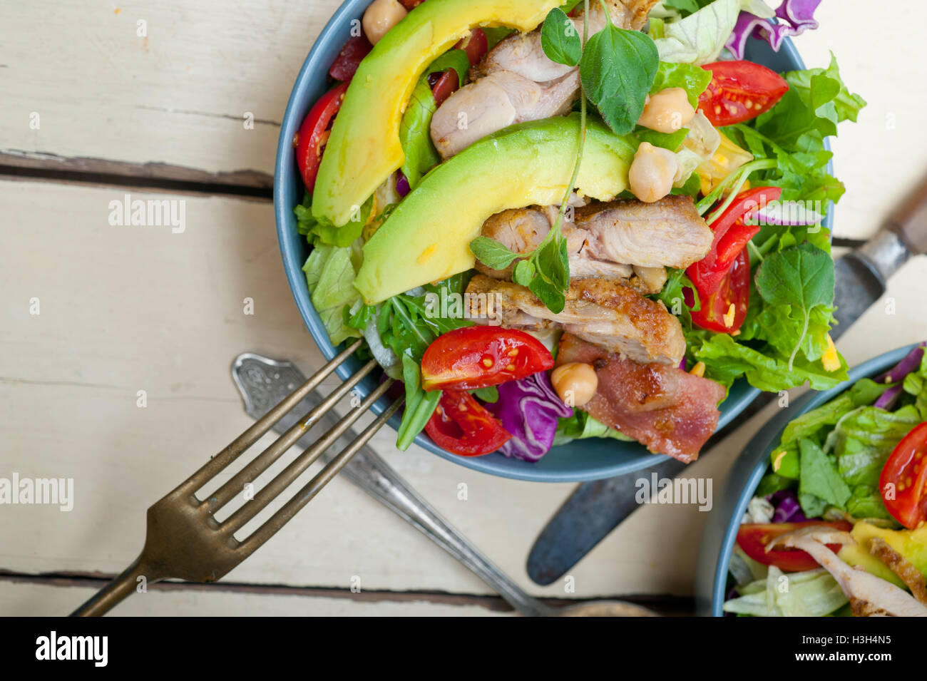 Frische und gesunde Hähnchen Avocado Salat über rustikalen Holztisch Stockfoto