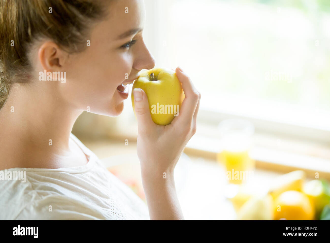Porträt von einer attraktiven Frau einen Apfel essen Stockfoto
