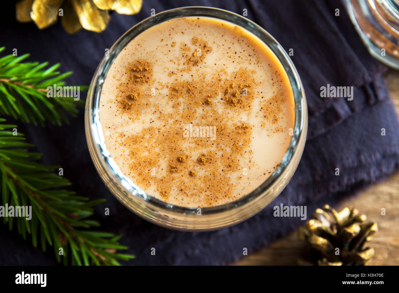 Eierlikör mit Zimt im Glas hautnah mit Weihnachts-Dekor - hausgemachte traditionelle festliche Getränk für die Weihnachtszeit Stockfoto