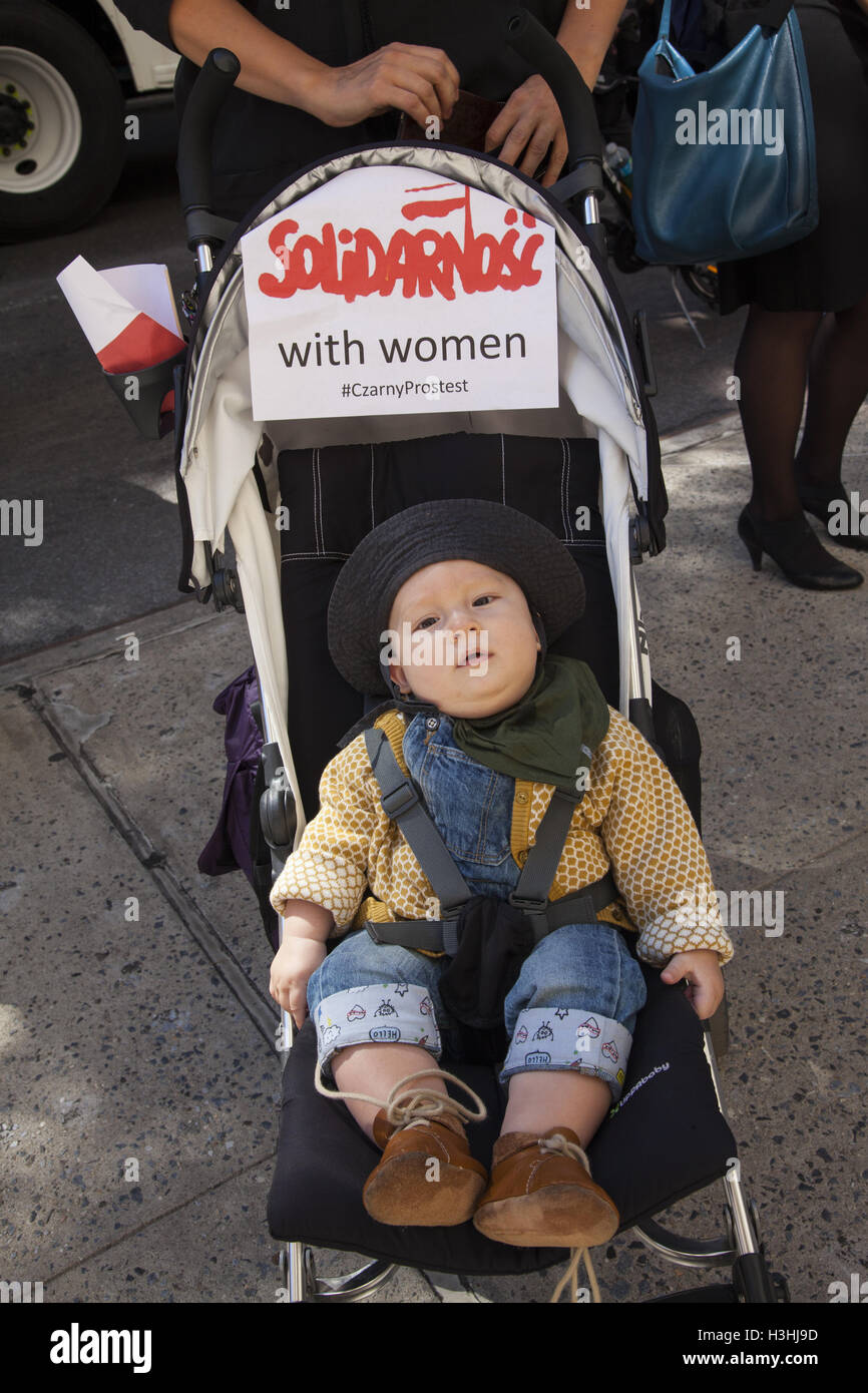 Polnisches Baby auf der Madison Avenue in New York City in der Nähe des polnischen Konsulats. Mutter zeigt ihre Abneigung gegen bestimmte politische Maßnahmen der neuen konservativen polnischen Regierung, die die Rechte von Frauen, insbesondere Fragen der Abtreibungsrechte, eingreifen. Stockfoto