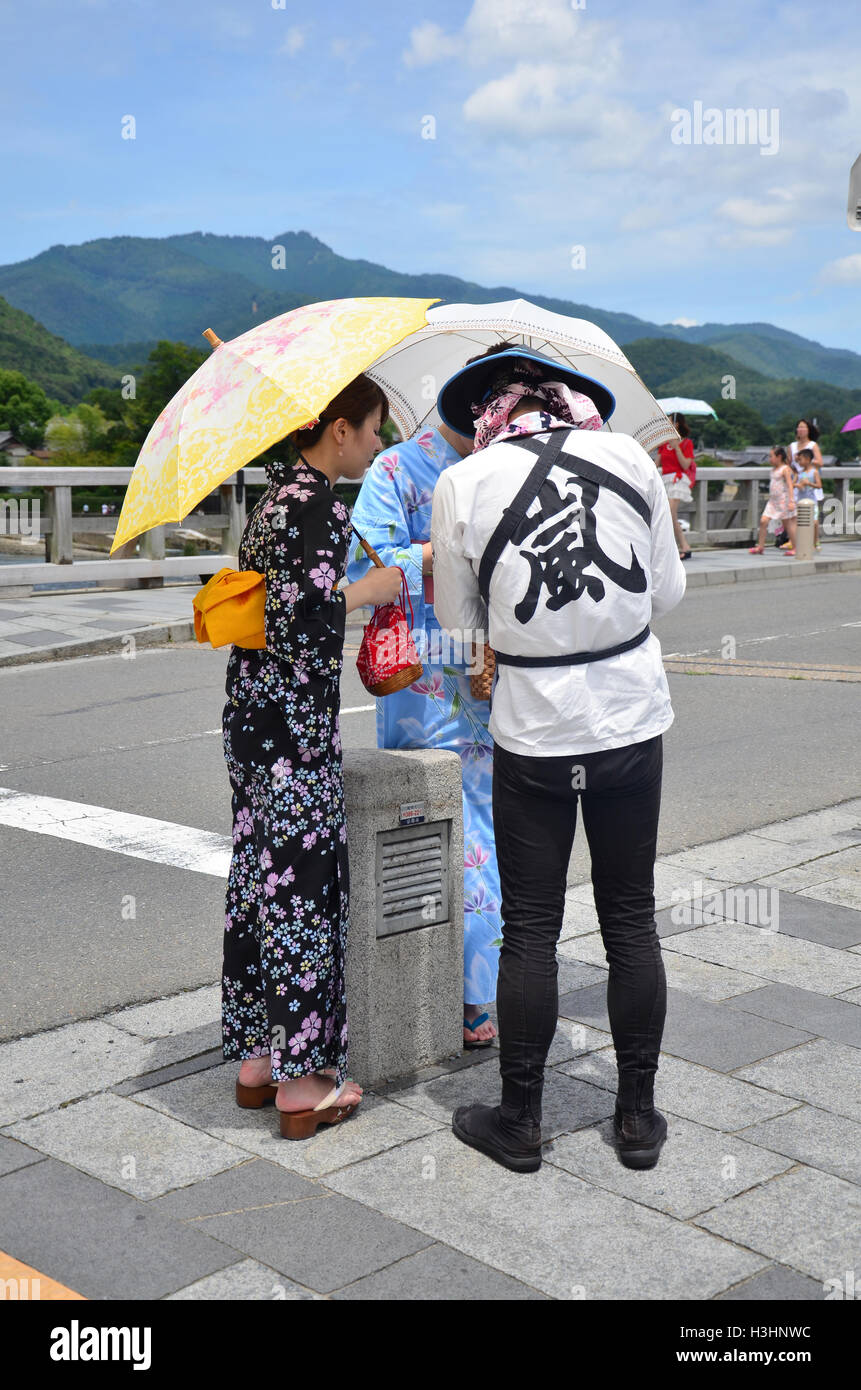 Fahrer-Rikscha-Präsentation über Rundgang durch Arashiyama Stadt für Reisende an der Togetsukyo Bridge über den Oi-Fluss am Arashiy Stockfoto
