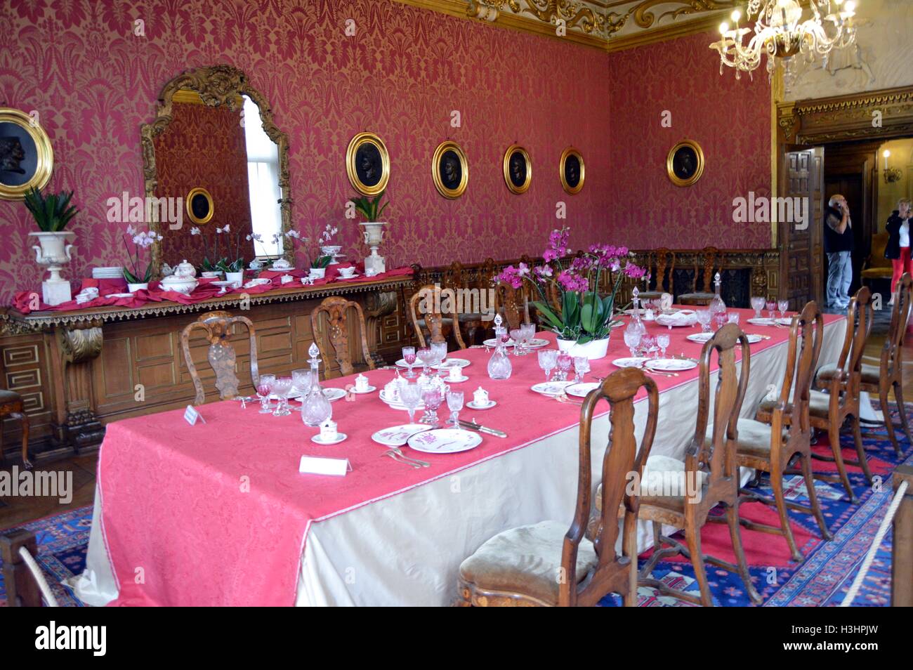 Tabelle der Mahlzeit erhöht bei allen Gerichten in einem großen roten Zimmer. Stockfoto