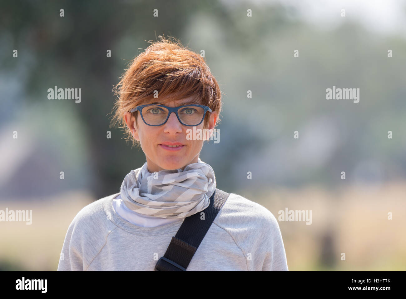 Porträt einer roten dunkelhaarige Frau mit grünen Augen, Brillen und fröhlichen Gesichtsausdruck. Tageslicht, natürliche Hautpflege, erschossen Stockfoto