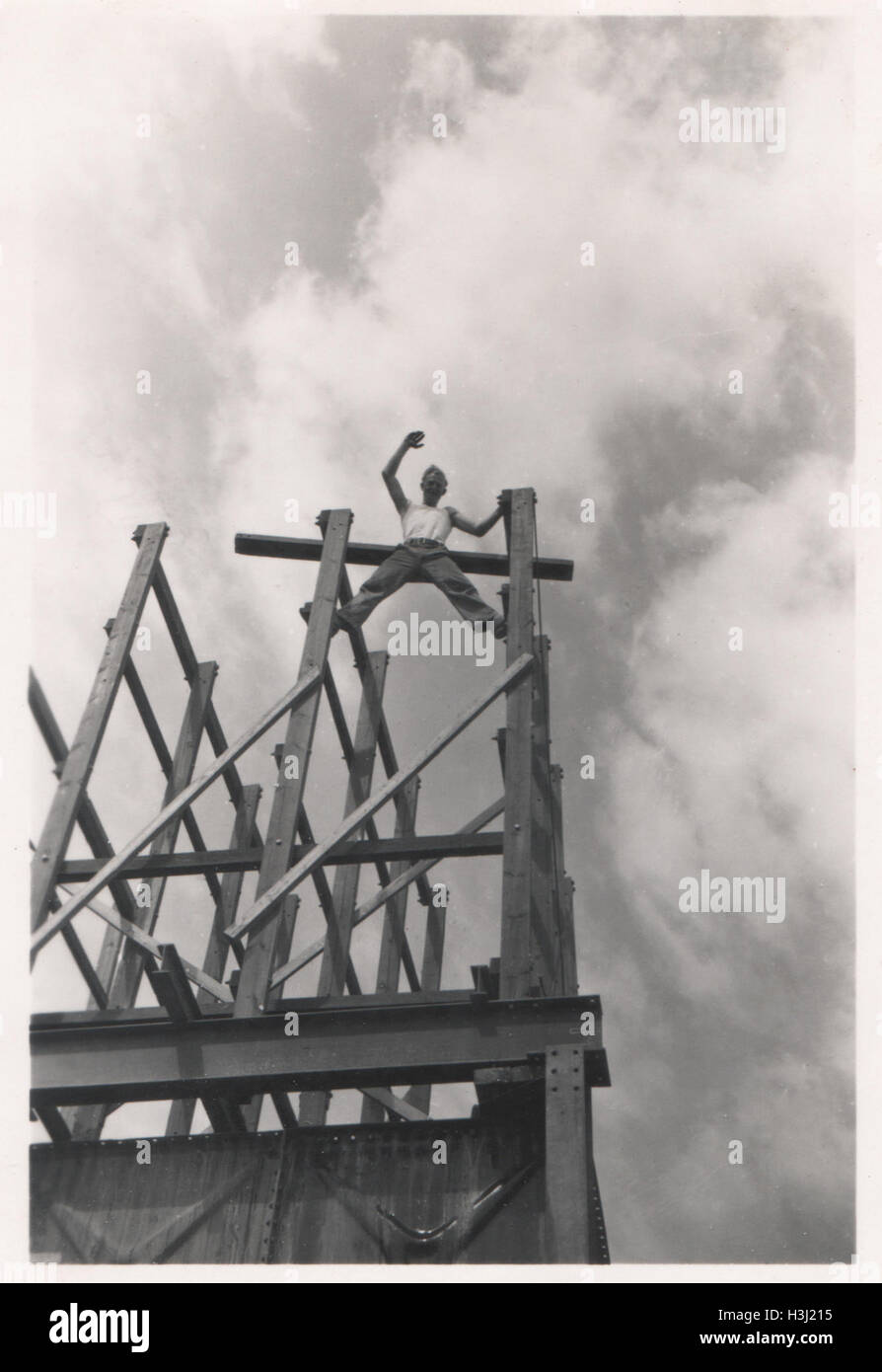 Bauarbeiter, der in einer prekären Position steht und auf einer Baustelle auf Trägern winkt. Das Foto wurde 10 im Base Ordnance Depot Royal Army Ordnance Corps (RAOC) im Gebiet Genefa Ismailia in der Nähe des Suezkanals 1952 aufgenommen. Stockfoto