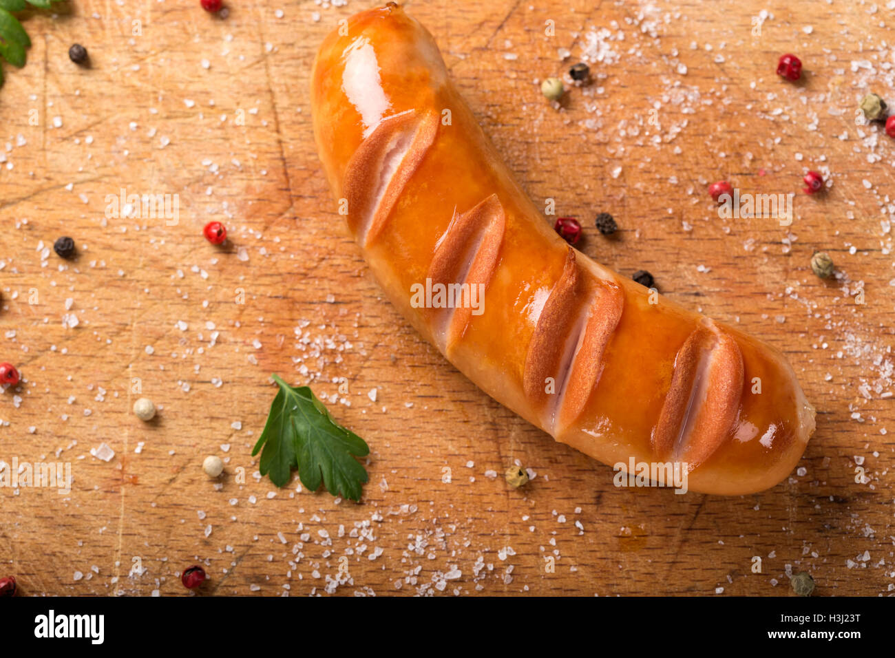 Fried polnische Wurst auf einem Holzbrett mit Kräutern Stockfoto