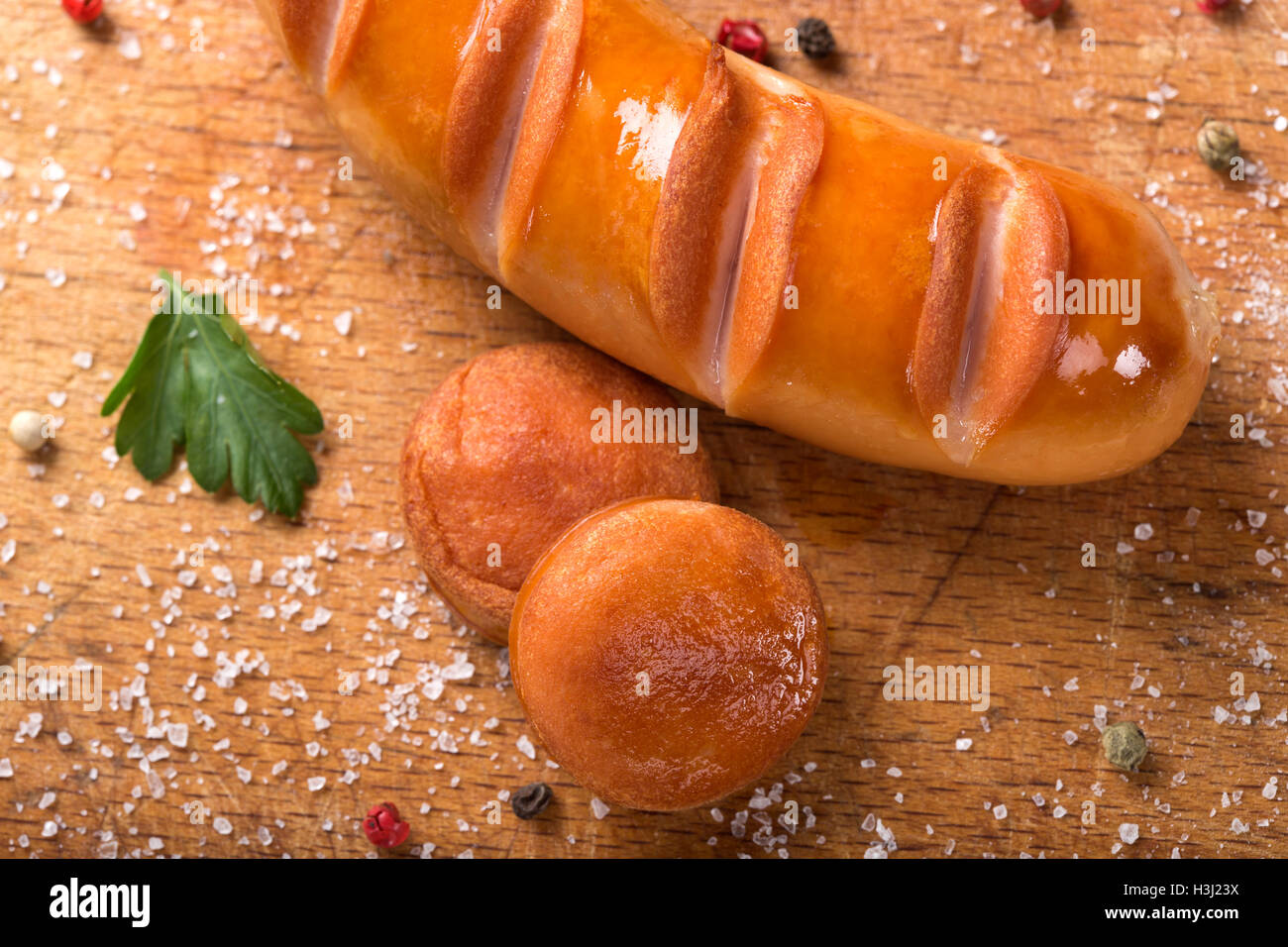 Fried polnische Wurst und zwei Scheiben auf einem Holzbrett mit Kräutern Stockfoto