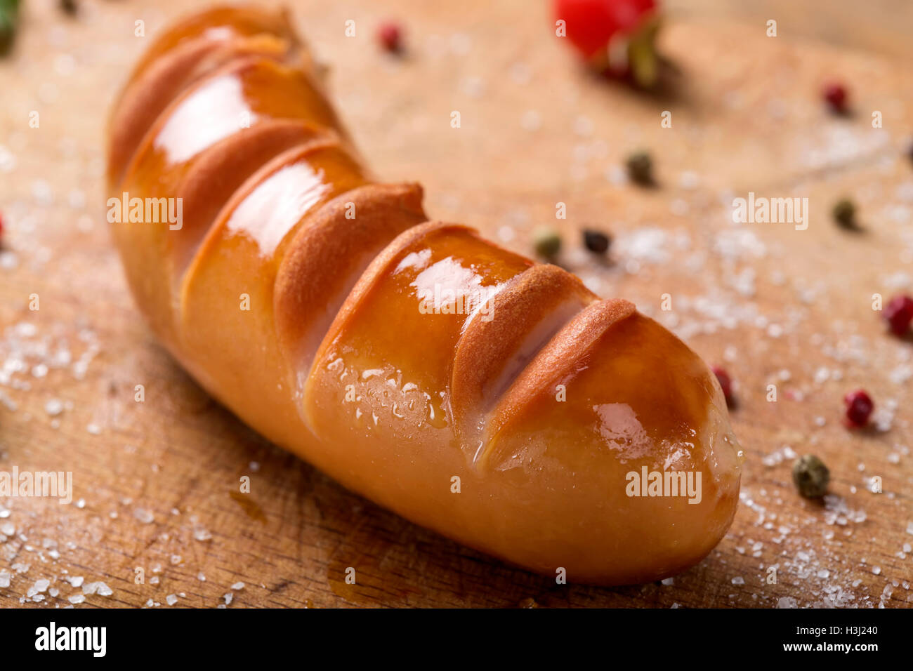 Nahaufnahme von einem polnischen Bratwurst auf einem Holzbrett mit Kräutern Stockfoto