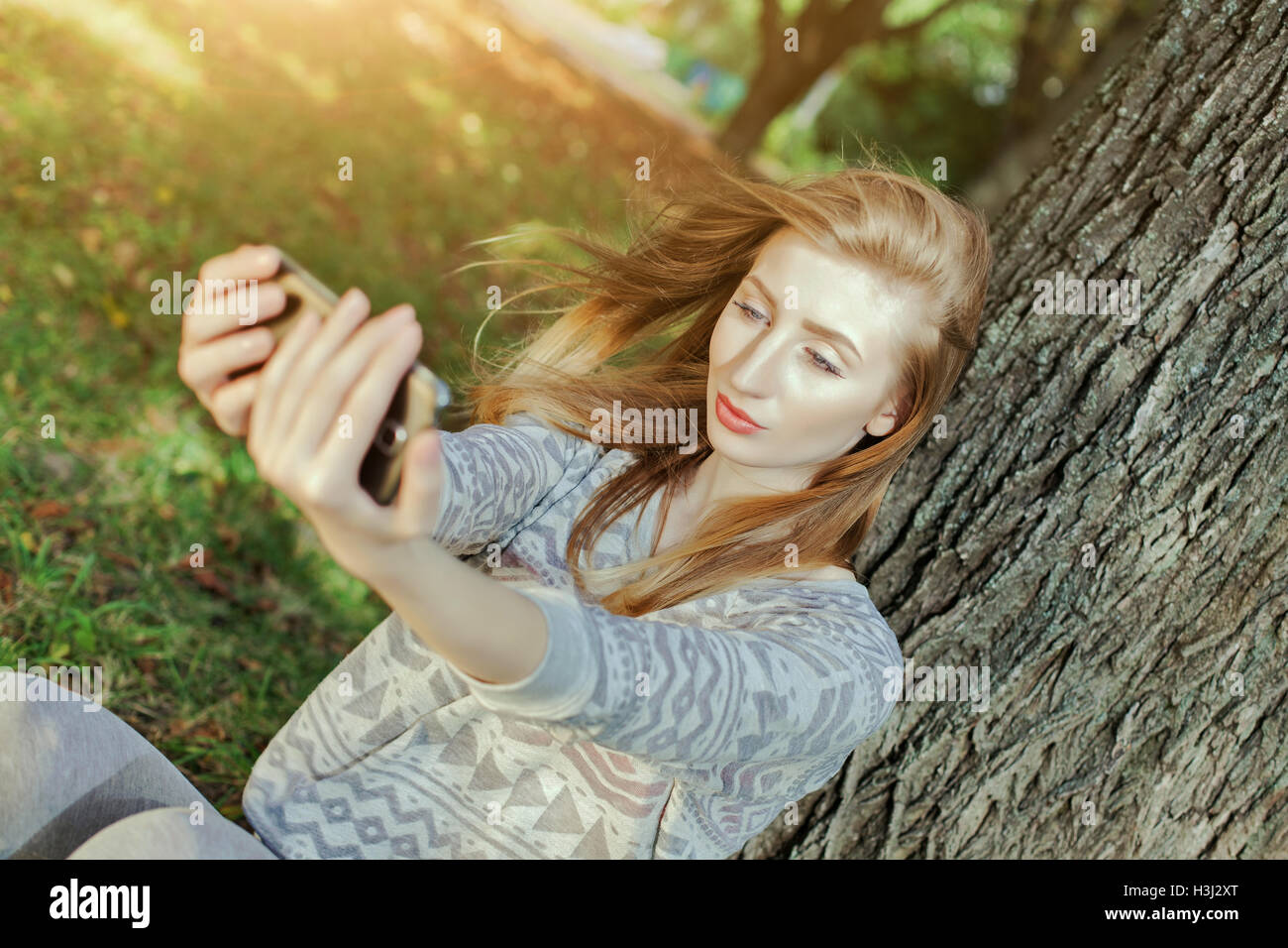 Schöne Mädchen mit blauen Augen macht Selfie im freien Stockfoto