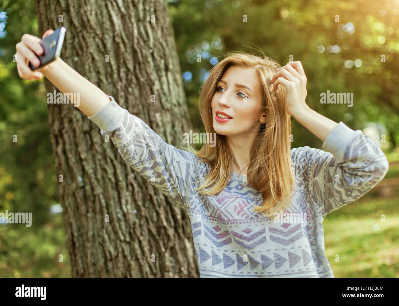 Schöne Mädchen mit blauen Augen macht Selfie im freien Stockfoto