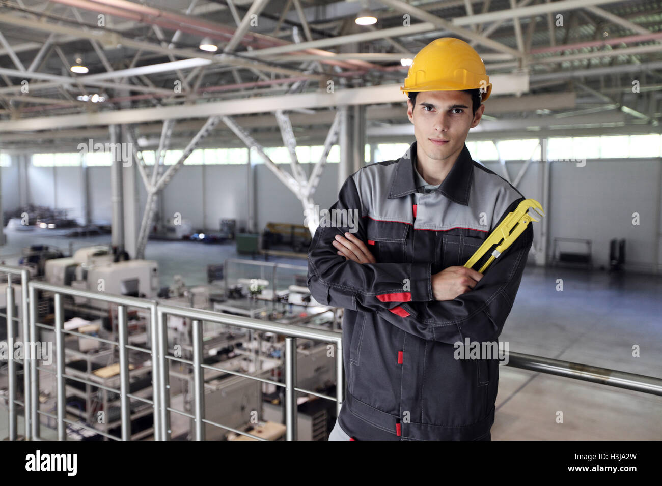 Porträt eines jungen Arbeiters mit Schraubenschlüssel an CNC-Fabrik Stockfoto Porträt eines jungen Arbeiters mit Schraubenschlüssel an CNC-Fabrik Stockfoto
