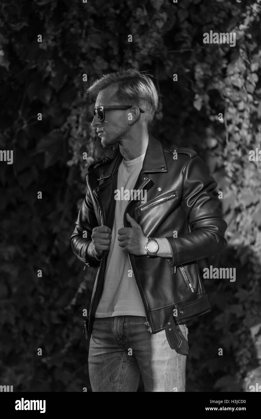 junger Mann posiert in Leder Jacke coole modische schwarz / weiß Stockfoto