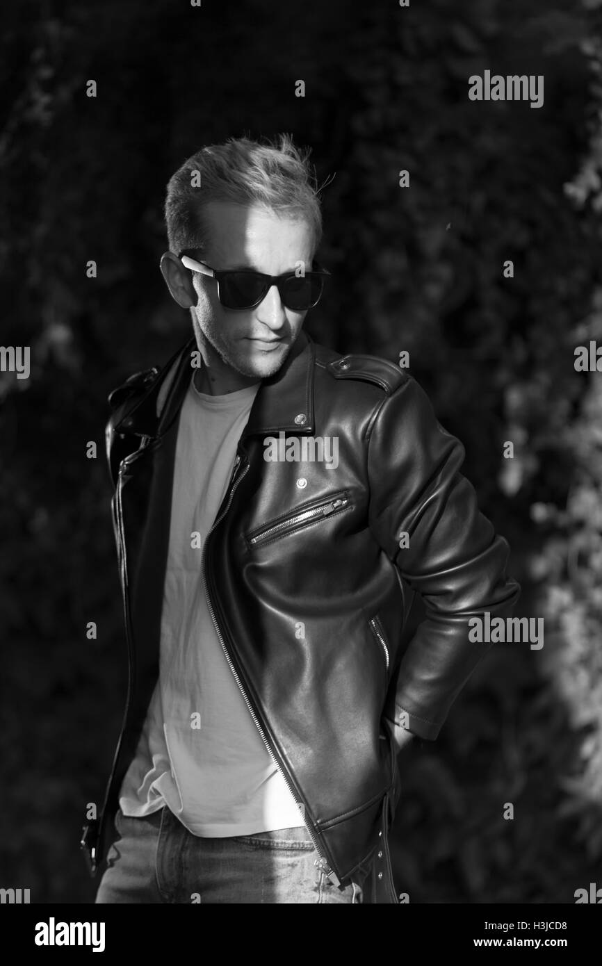 junger Mann posiert in Leder Jacke coole modische schwarz / weiß Stockfoto