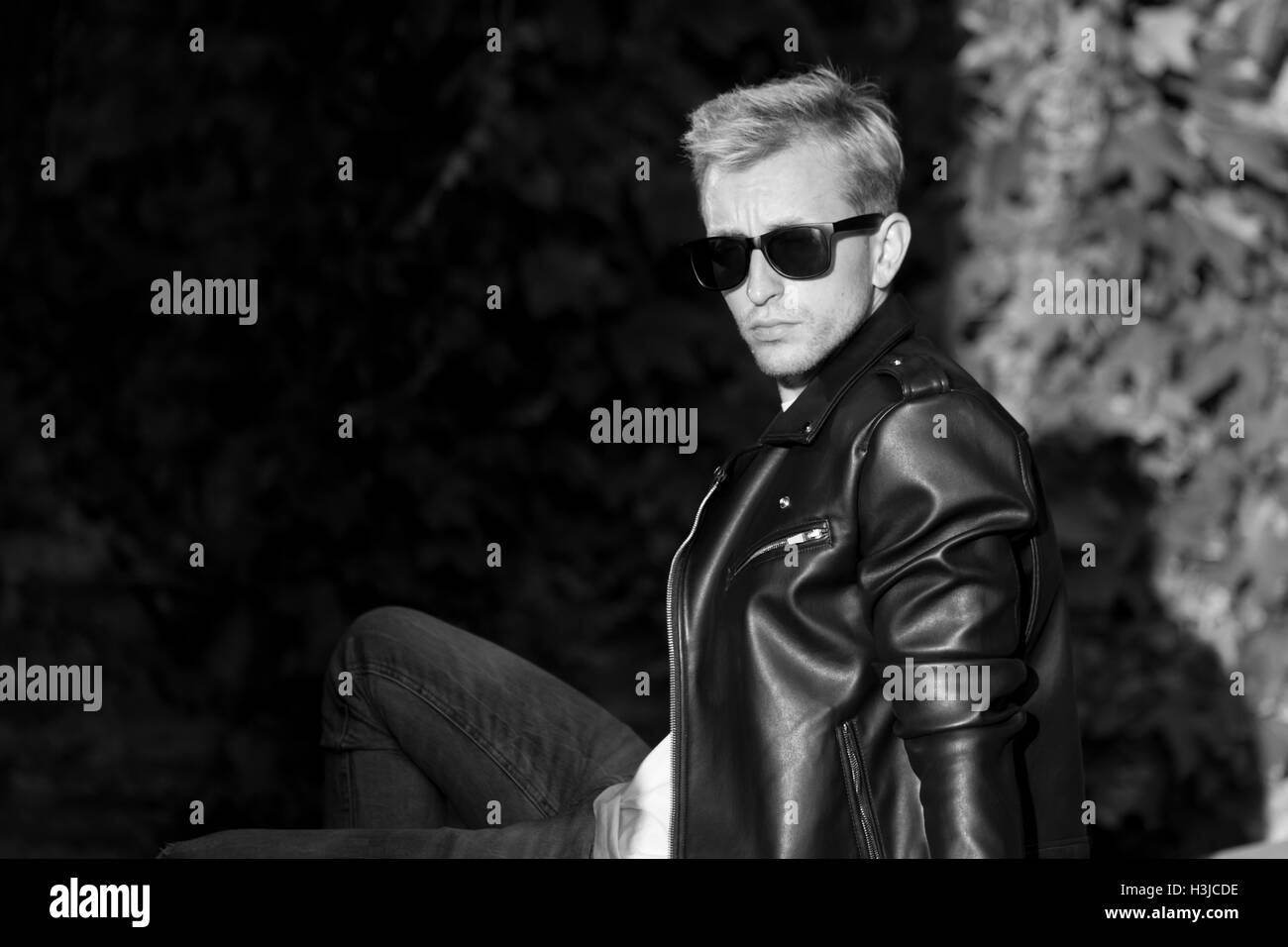 junger Mann posiert in Leder Jacke coole modische schwarz / weiß Stockfoto