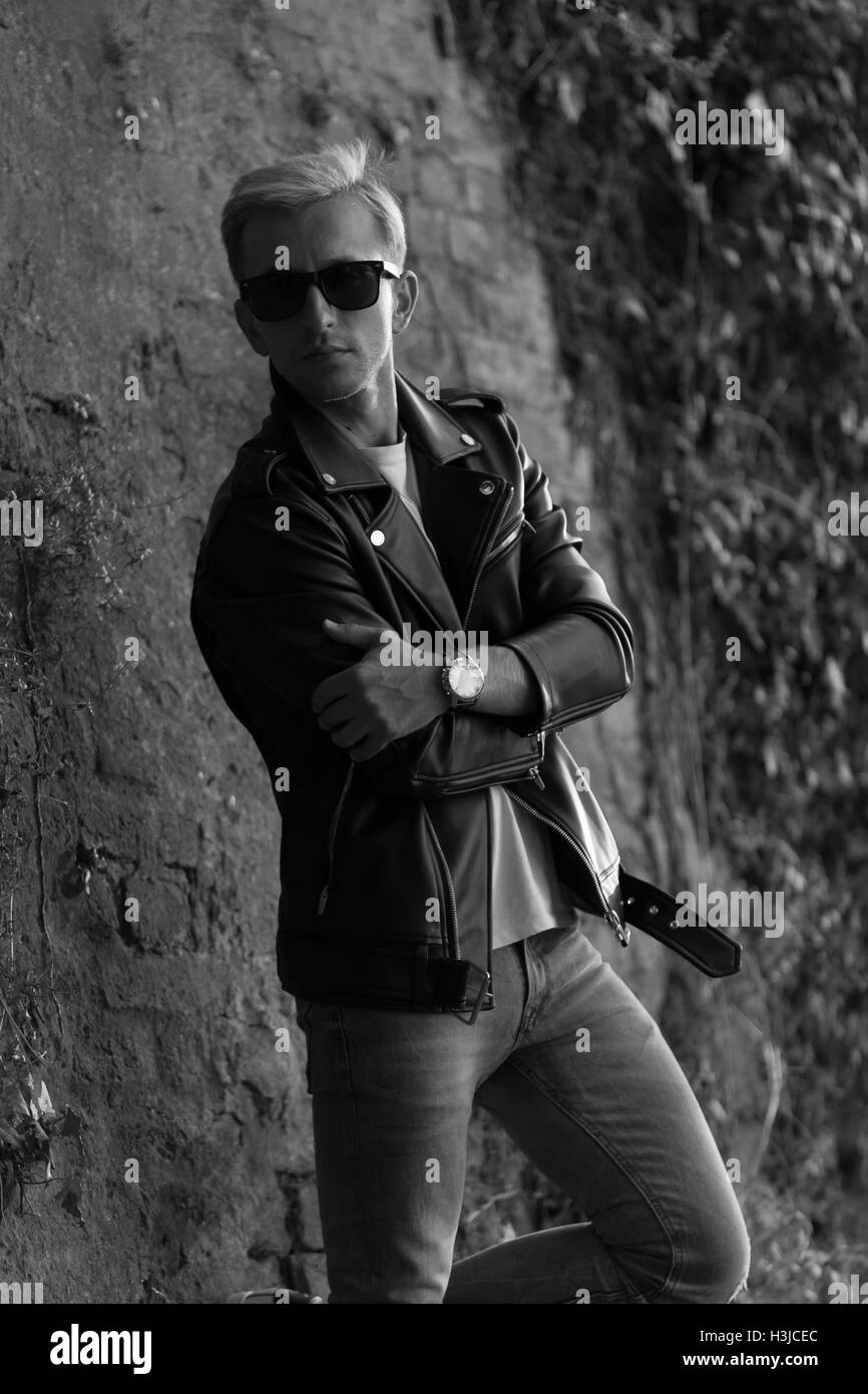 junger Mann posiert in Leder Jacke coole modische schwarz / weiß Stockfoto