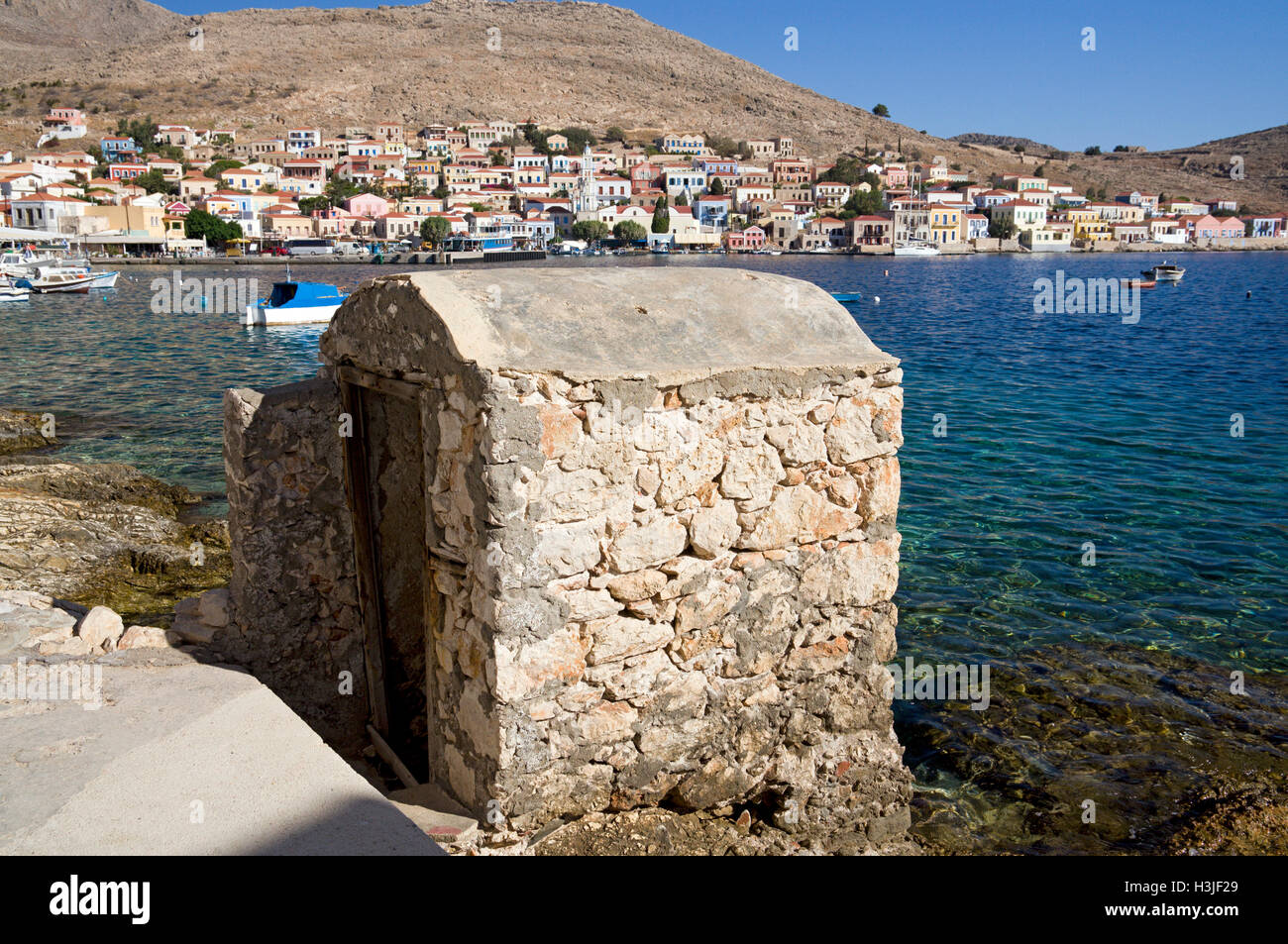 Alten stillgelegten Außentoilette, mündet direkt in den Hafen, Chalki Insel in der Nähe von Rhodos, Dodekanes, Griechenland. Stockfoto