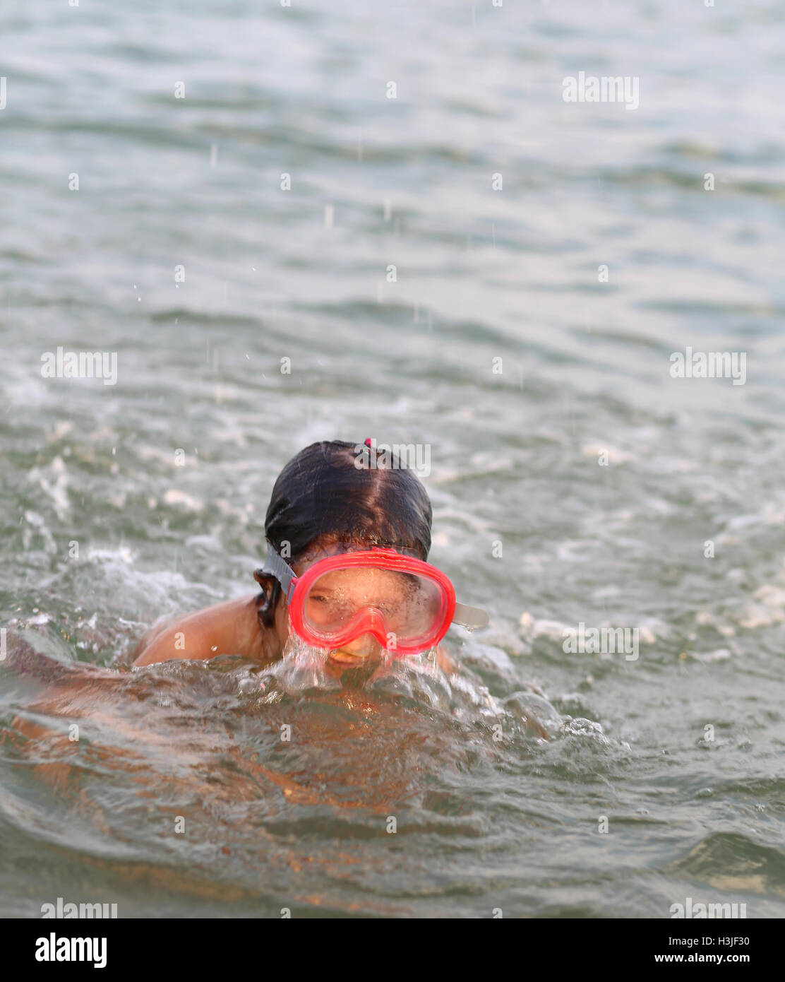 wunderschönes kleines Mädchen Lächeln während des Spiels mit der Maske unter Wasser tauchen Stockfoto
