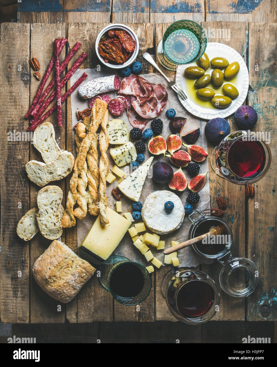 Wein und snack-Set mit verschiedenen Weinen in Gläser, verschiedene Fleisch, Brot, sonnengetrocknete Tomaten, Honig, grüne Oliven, Feigen, Nüssen und f Stockfoto