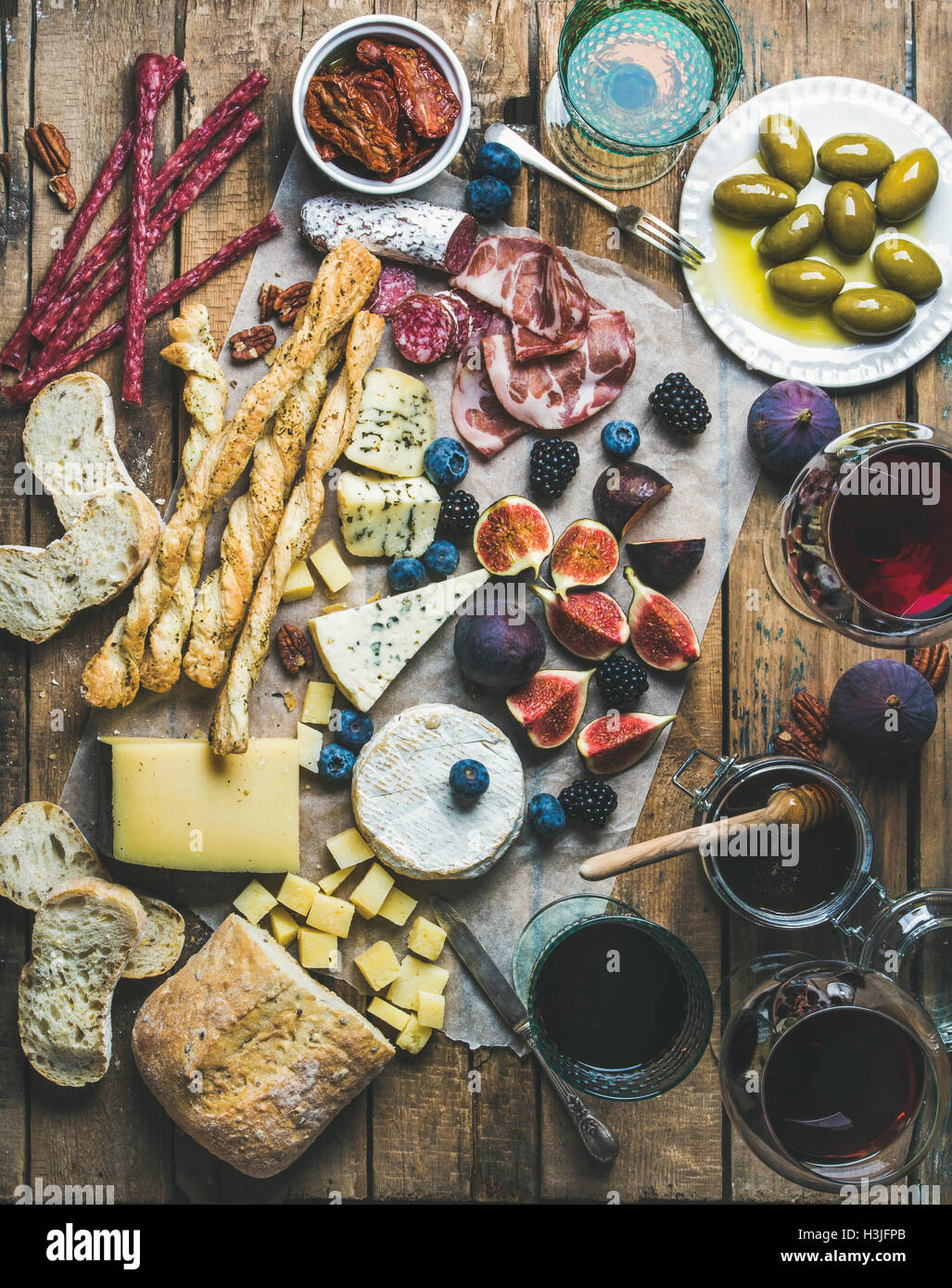 Wein und snack-Set mit verschiedenen Weinen in Gläser, Fleisch-Vielfalt, Brot, grüne Oliven, getrockneten Tomaten, Feigen, Nüssen und Beeren Stockfoto