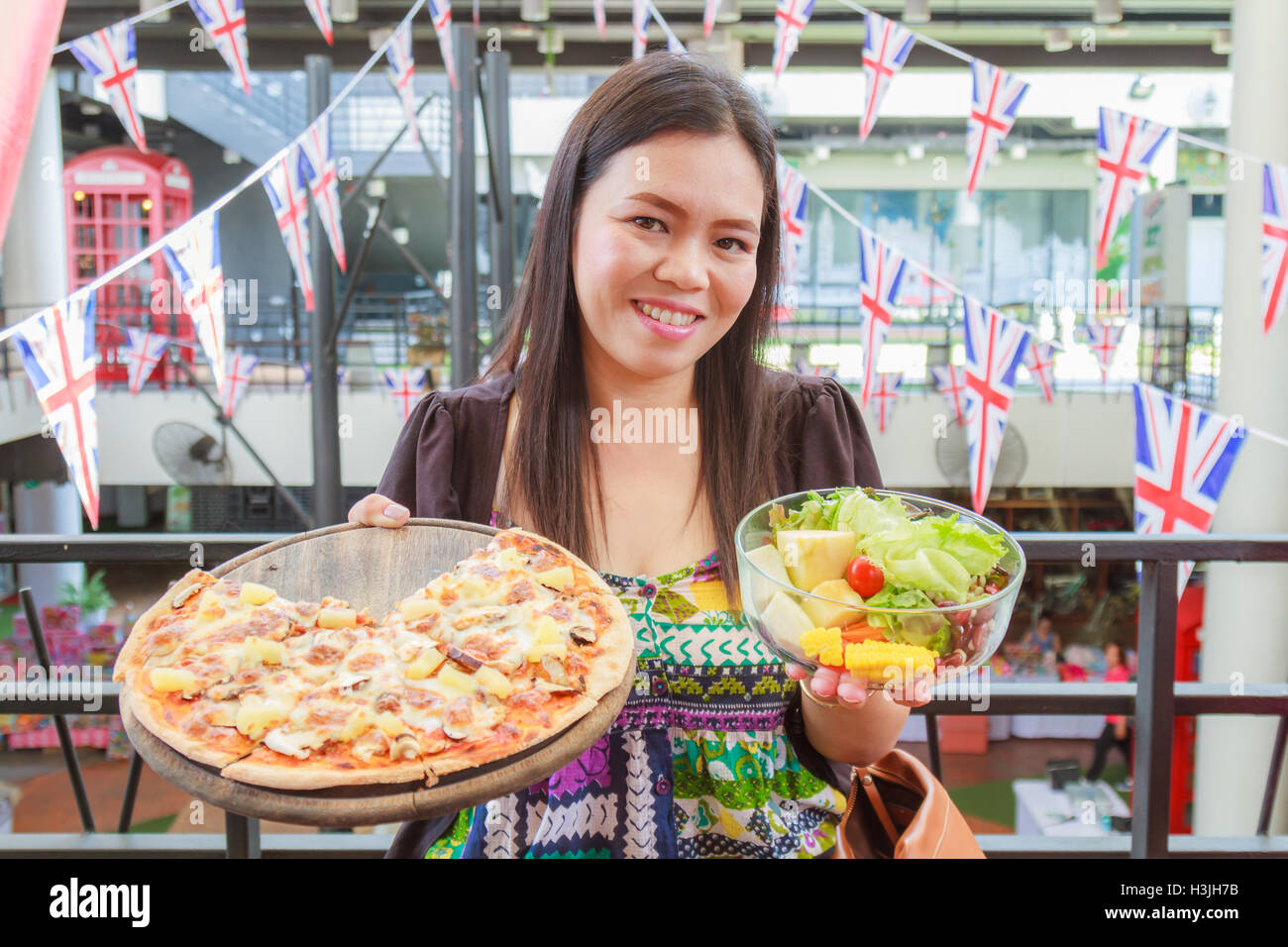 Asia Girl Wahl Essen Pizza oder Salat im restaurant Stockfoto