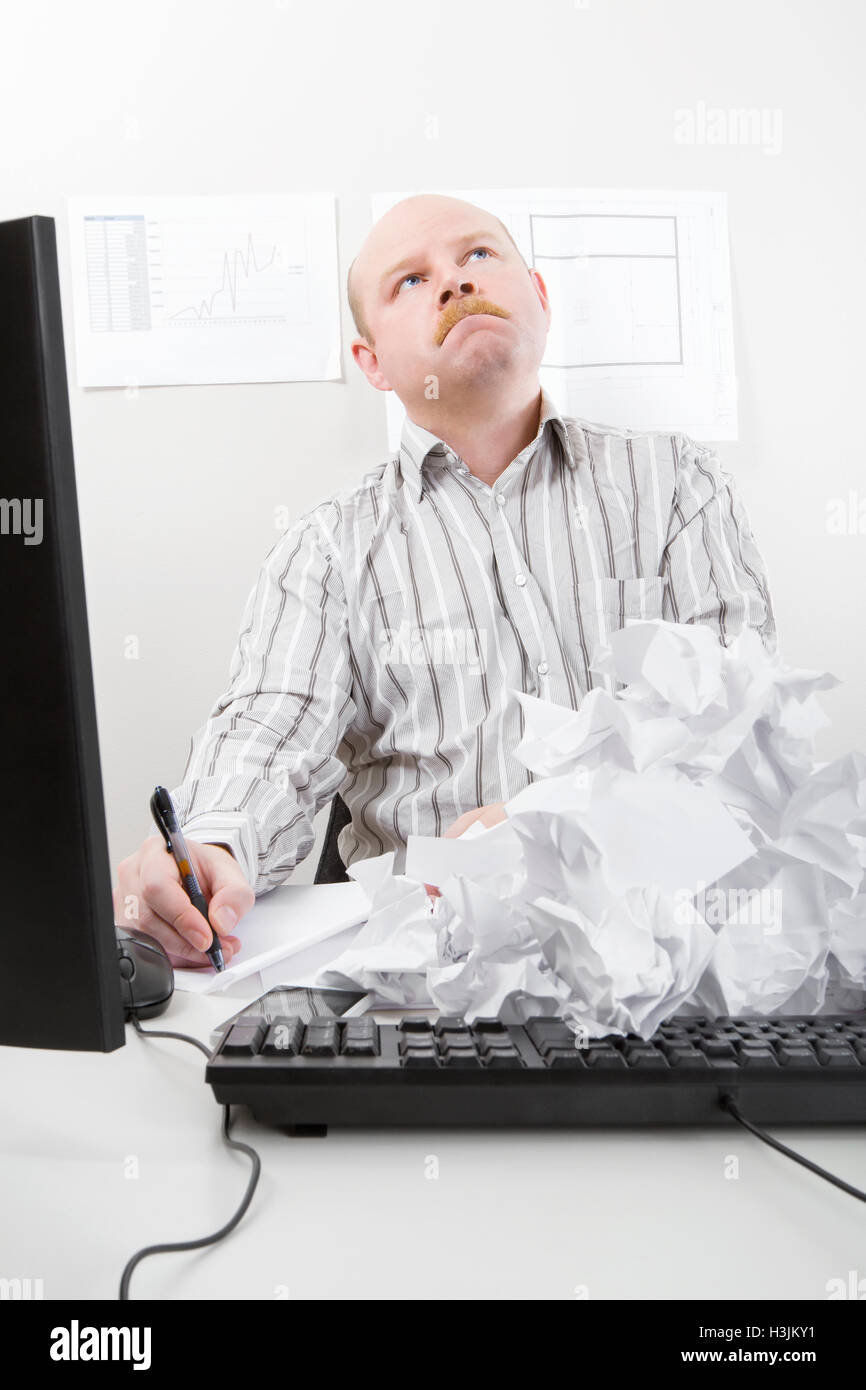 Geschäftsmann schreiben mit abgelehnten Papieren auf Tastatur Stockfoto