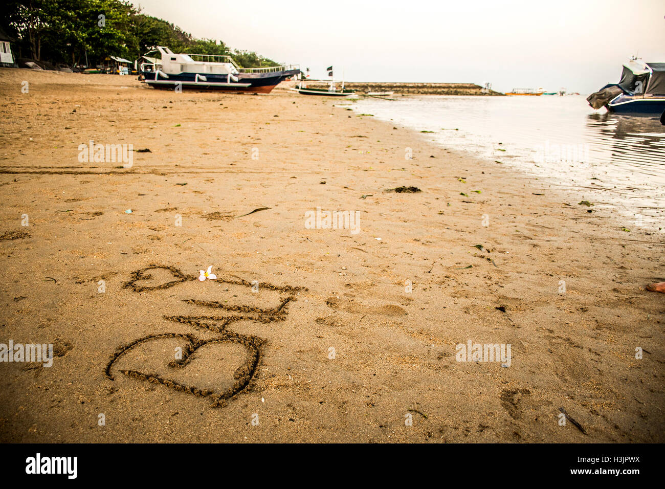 Bali Indonesien geschrieben im Sand am Strand von Sanur Sonnenuntergang Stockfoto