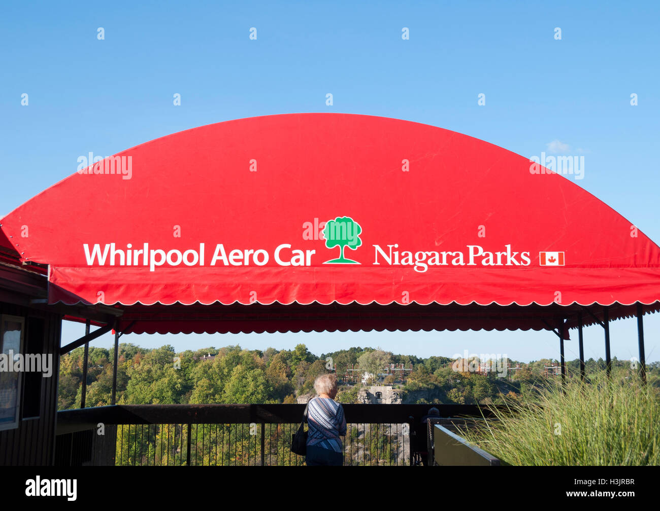 Eine ältere Frau beobachtet den Niagara Parks Aero Car, eine historische Touristenseilbahn, die seit 1913 die Stromschnellen des Whirlpools überquert Stockfoto
