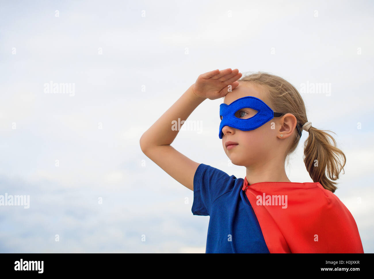 Superheld Kind vor blauem Himmelshintergrund. Stockfoto