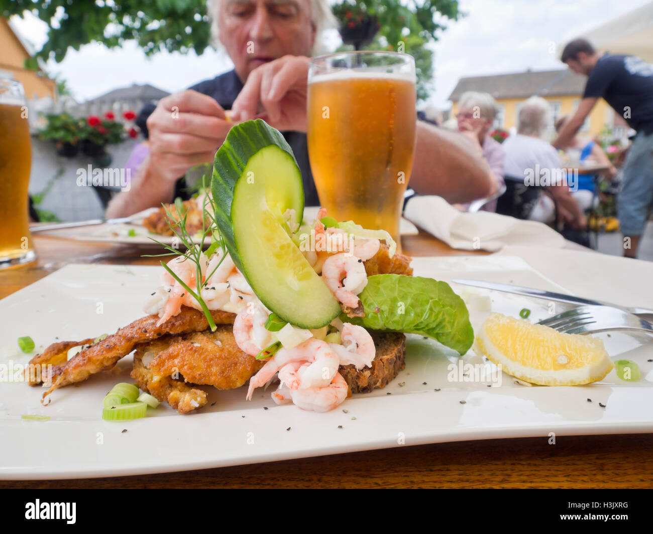 Offenen konfrontiert Sandwich mit Garnelen und Scholle, mit Bier und guter Gesellschaft, ein Restaurant im Freien in Drobak Norwegen Stockfoto