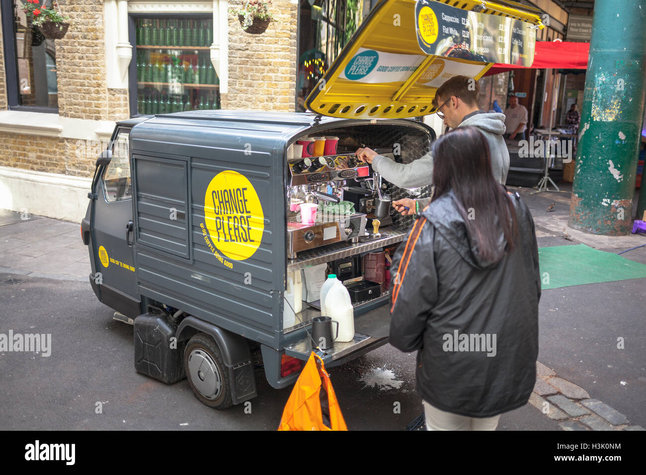 Borough Market, London UK. Frau Kaffee von einer ambulanten Dreirad motor Verkäufer kaufen Stockfoto
