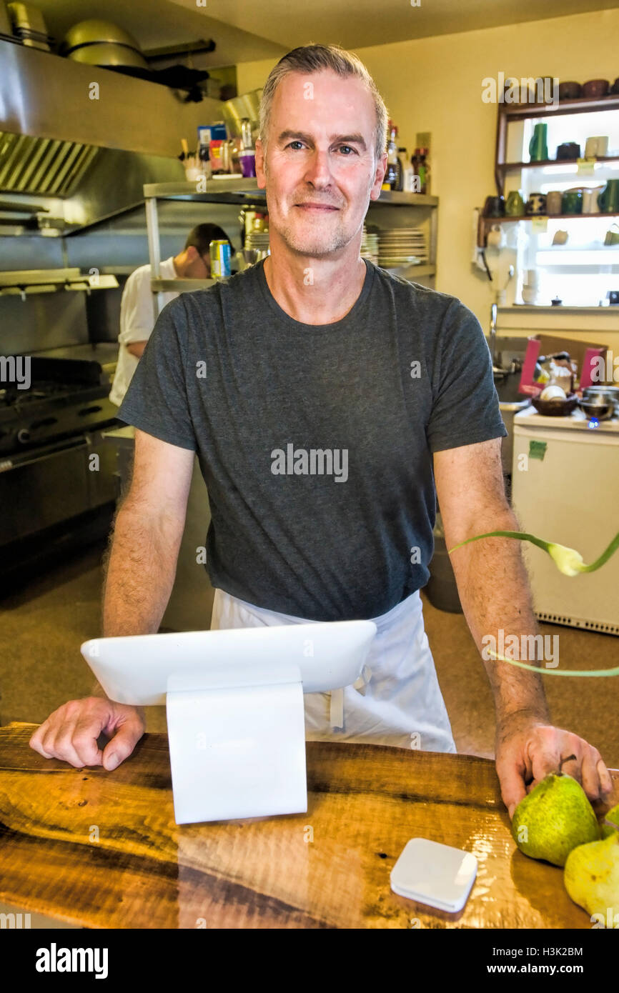 Café-Besitzer, die lächelnd hinter Service-counter Stockfoto