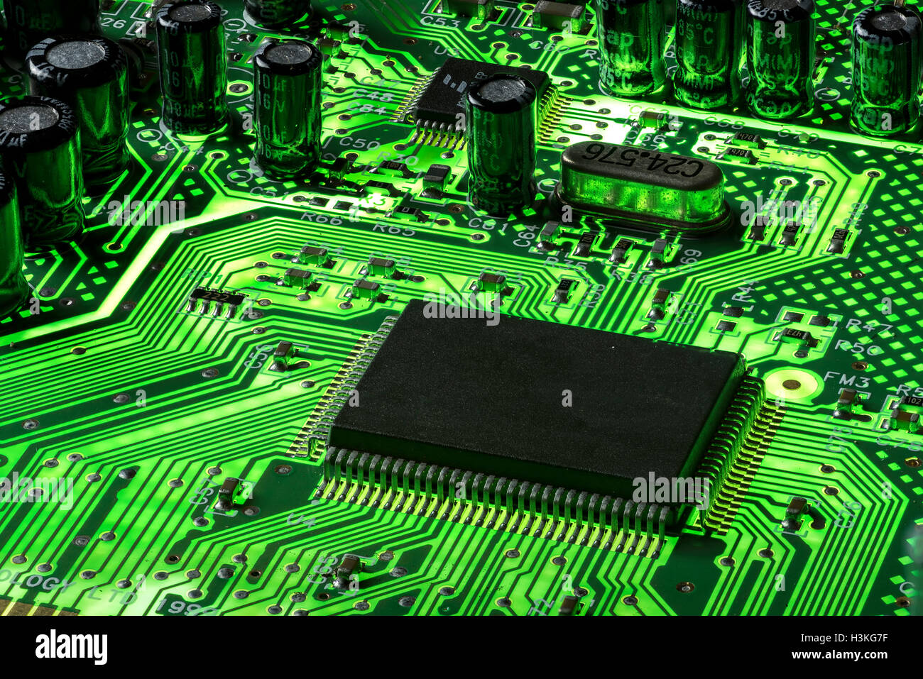 Mainboard mit grüner Leuchtstoffröhre und schwarzer CPU, die das energieeffiziente Design und die modernsten technischen Komponenten sowie die energieeffiziente Technologie hervorheben Stockfoto