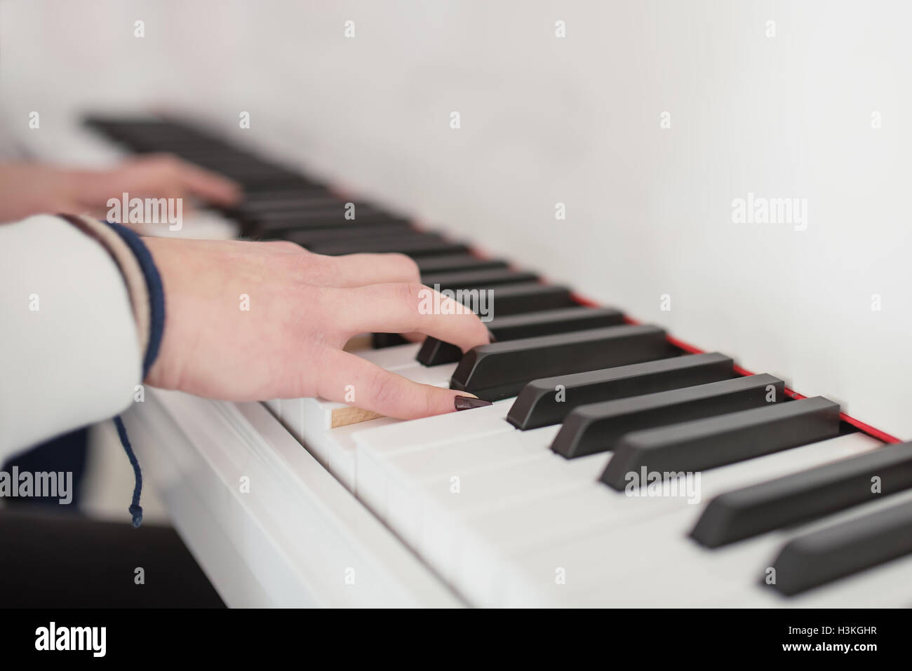 Frauen Hände auf der Tastatur des Klaviers Stockfoto