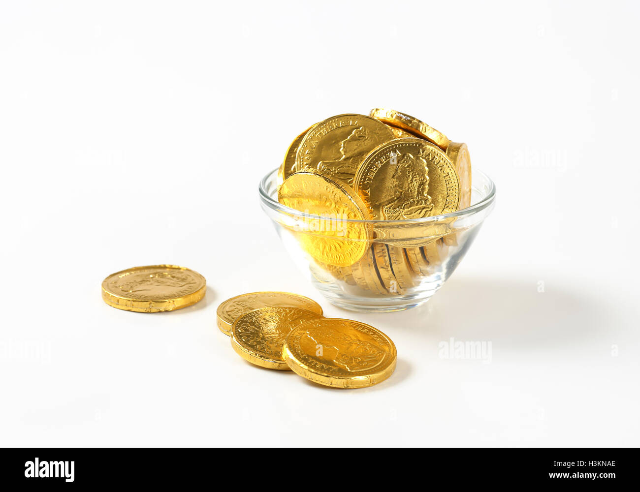 Schüssel mit Schokoladen-Münzen auf weißem Hintergrund Stockfoto
