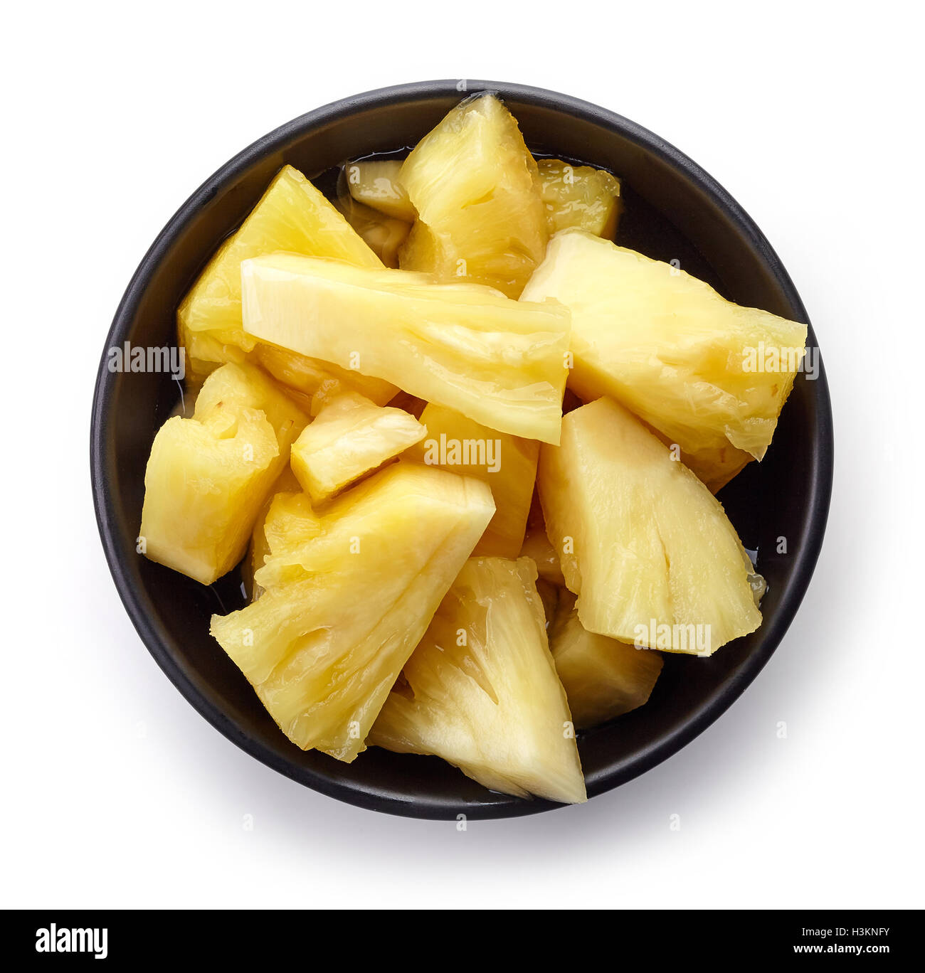 Schüssel mit Konserven Ananas Stücke isoliert auf weißem Hintergrund, Ansicht von oben Stockfoto