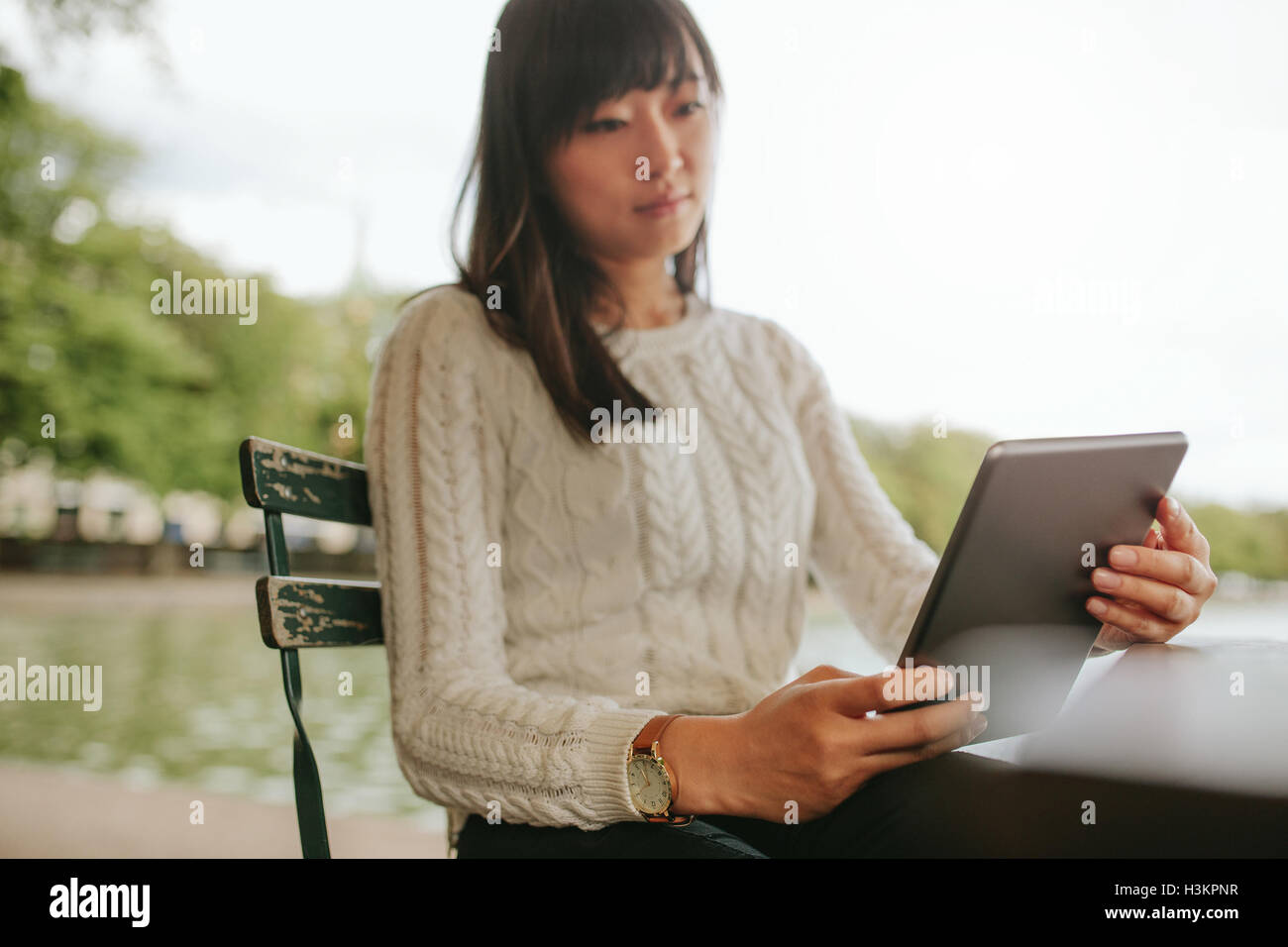 Junge Frau lesen Ebook auf ihrem digital-Tablette. Chinesische Frauen in Straßencafé mit digital-Tablette. Stockfoto