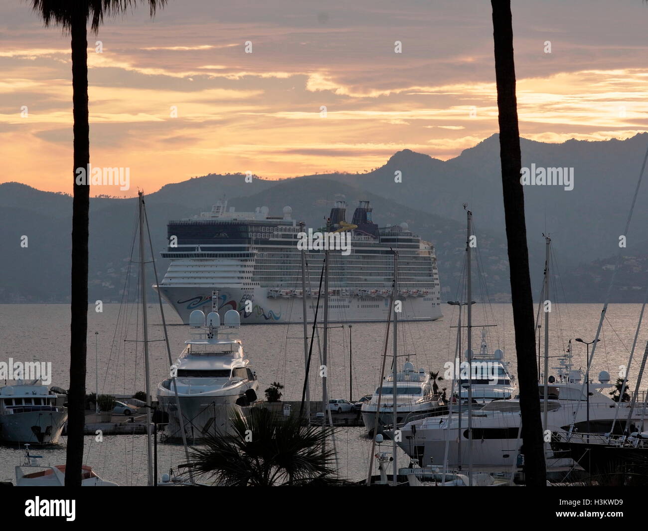 AJAXNETPHOTO. 2016. CANNES, FRANKREICH. -COTE D ' AZUR RESORT - BLICK NACH WESTEN ÜBER DIE BUCHT VON CANNES BEI SONNENUNTERGANG MIT NORWEGIAN CRUISE LINE NORWEGIAN EPIC CRUISE SCHIFF IN DIE BUCHT UND SUPERYACHTEN UND MOTOR KREUZER VOR ANKER IM HAFEN PIERRE CANTO MARINA (VORDERGRUND) VERANKERT.  FOTO: JONATHAN EASTLAND/AJAX REF: GX160710 6438 Stockfoto